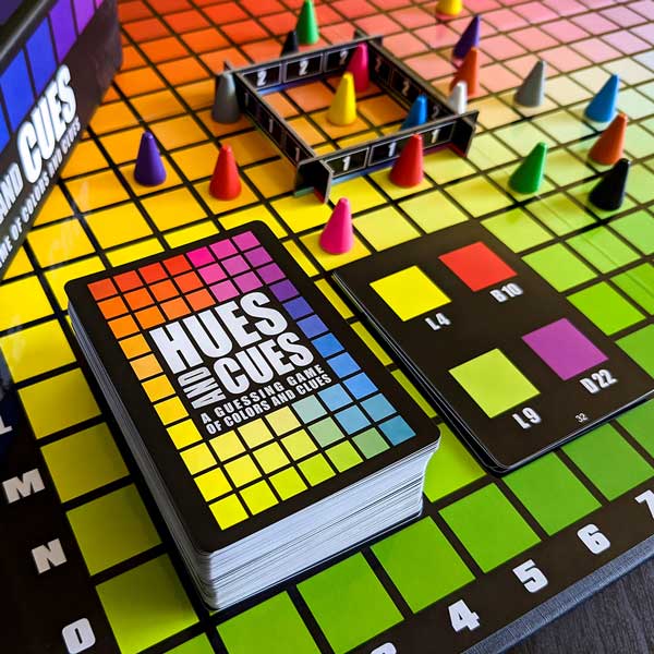 Hues and Cues cards, pawns, and scoring frame set up on the color board